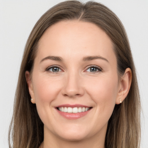 Joyful white young-adult female with long  brown hair and grey eyes