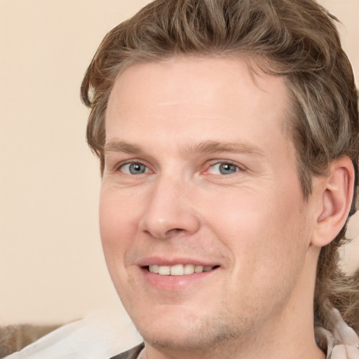 Joyful white adult male with short  brown hair and grey eyes