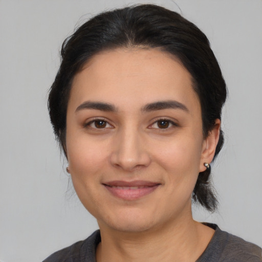 Joyful latino young-adult female with medium  black hair and brown eyes