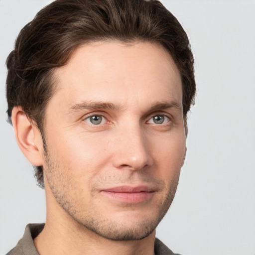 Joyful white young-adult male with short  brown hair and grey eyes