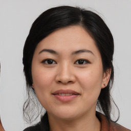 Joyful asian young-adult female with medium  brown hair and brown eyes