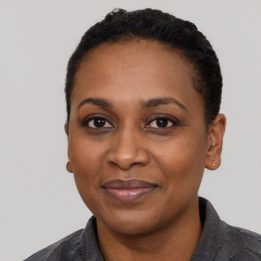 Joyful black young-adult female with short  black hair and brown eyes