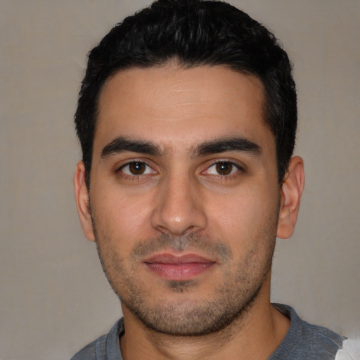 Joyful white young-adult male with short  black hair and brown eyes
