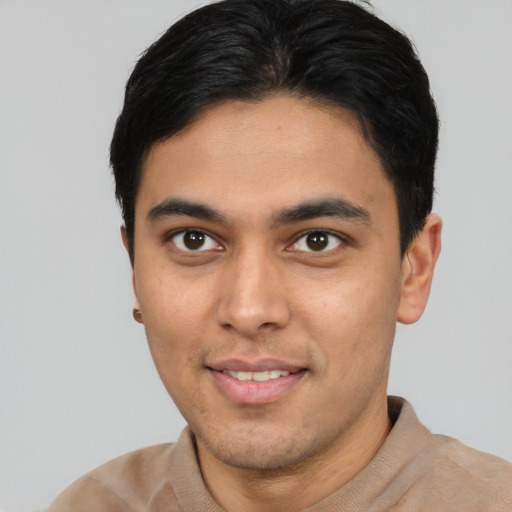 Joyful latino young-adult male with short  brown hair and brown eyes