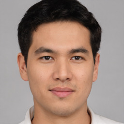 Joyful asian young-adult male with short  black hair and brown eyes