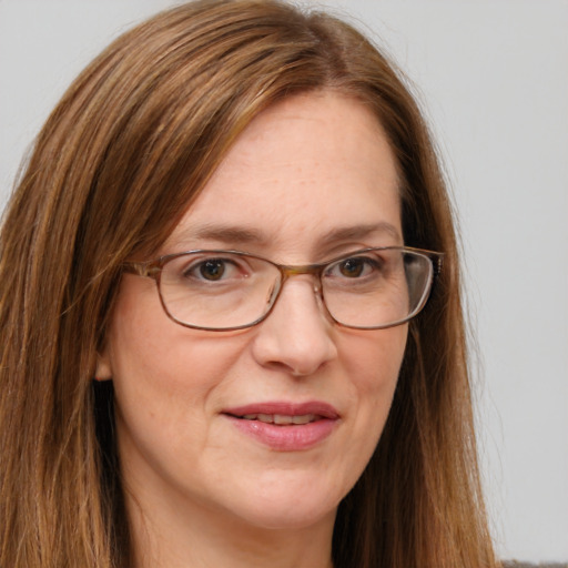 Joyful white adult female with long  brown hair and grey eyes