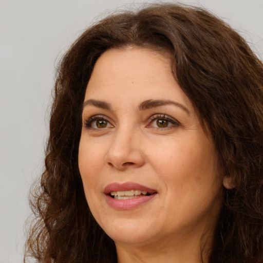 Joyful white adult female with long  brown hair and brown eyes