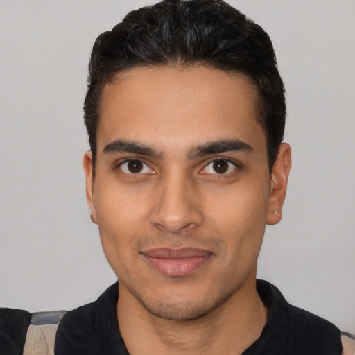 Joyful latino young-adult male with short  black hair and brown eyes