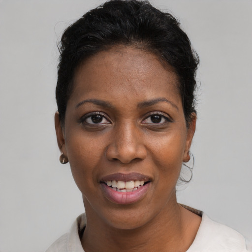 Joyful black young-adult female with short  black hair and brown eyes
