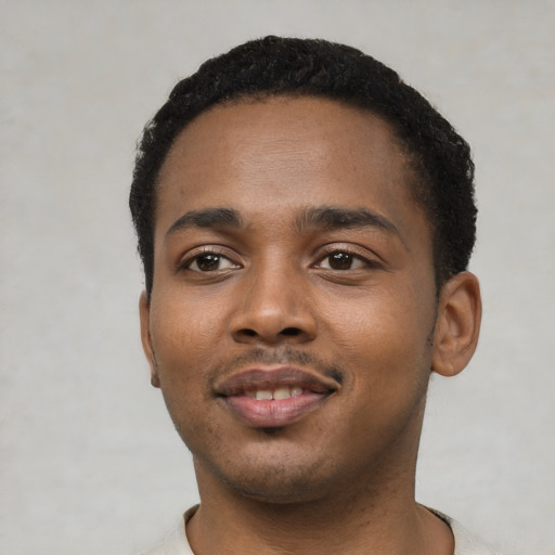 Joyful black young-adult male with short  black hair and brown eyes