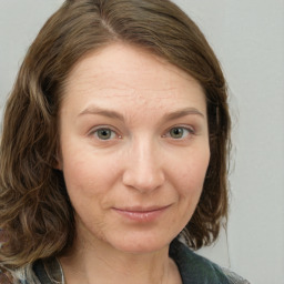 Joyful white young-adult female with medium  brown hair and green eyes