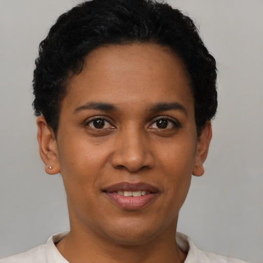 Joyful black young-adult female with short  black hair and brown eyes