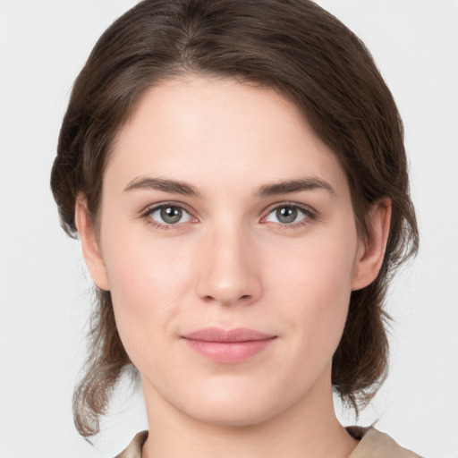 Joyful white young-adult female with medium  brown hair and grey eyes