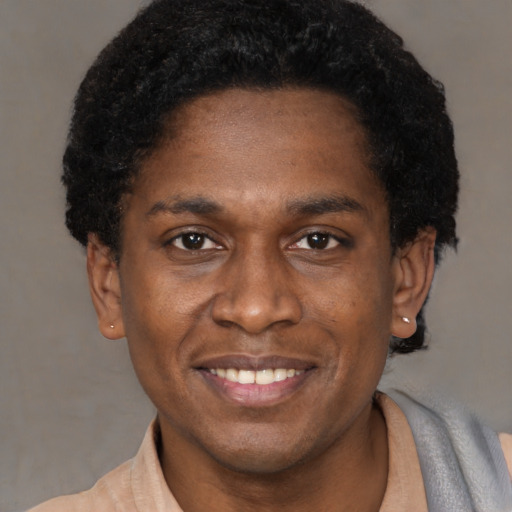 Joyful black young-adult male with short  brown hair and brown eyes