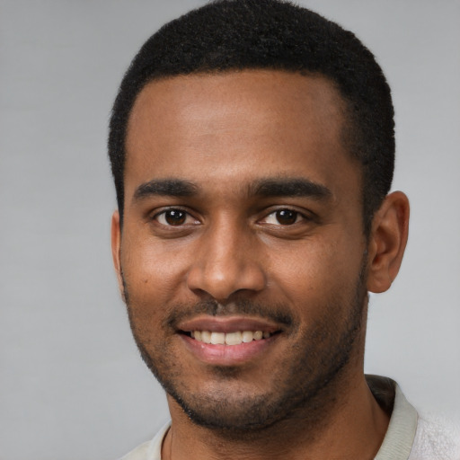 Joyful black young-adult male with short  brown hair and brown eyes