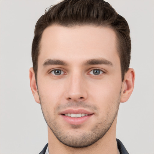 Joyful white young-adult male with short  brown hair and grey eyes