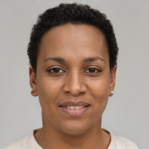 Joyful black young-adult female with short  black hair and brown eyes