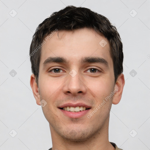 Joyful white young-adult male with short  black hair and brown eyes