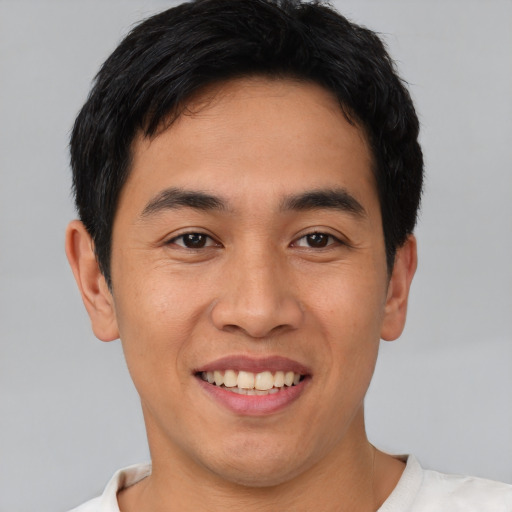 Joyful asian young-adult male with short  black hair and brown eyes