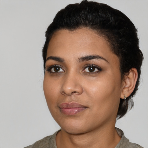Joyful latino young-adult female with short  black hair and brown eyes