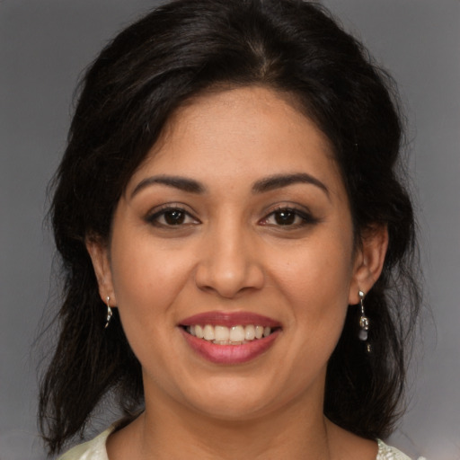 Joyful latino young-adult female with medium  brown hair and brown eyes