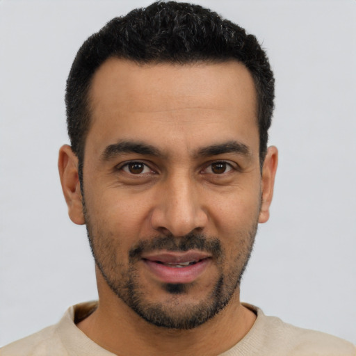 Joyful latino young-adult male with short  black hair and brown eyes