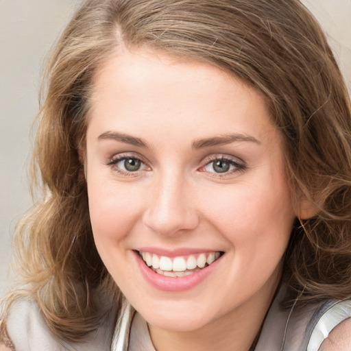 Joyful white young-adult female with medium  brown hair and blue eyes