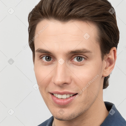 Joyful white young-adult male with short  brown hair and grey eyes