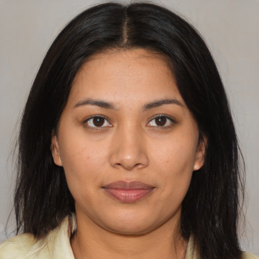 Joyful latino young-adult female with long  brown hair and brown eyes