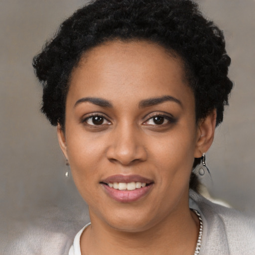 Joyful black young-adult female with short  black hair and brown eyes