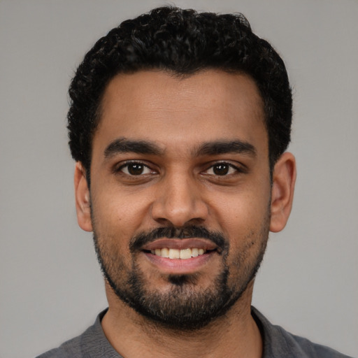 Joyful latino young-adult male with short  black hair and brown eyes