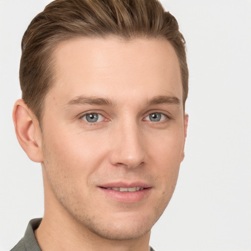 Joyful white young-adult male with short  brown hair and grey eyes