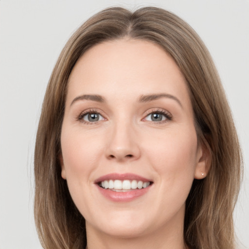 Joyful white young-adult female with long  brown hair and grey eyes