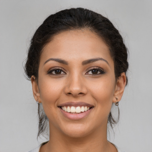 Joyful latino young-adult female with long  brown hair and brown eyes