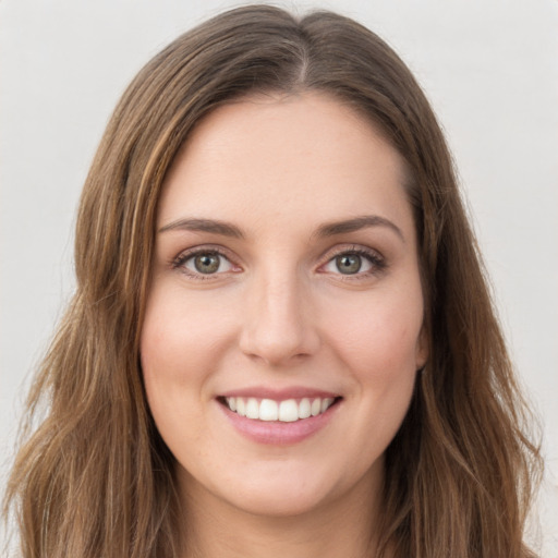 Joyful white young-adult female with long  brown hair and green eyes