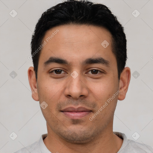 Joyful latino young-adult male with short  black hair and brown eyes