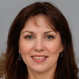 Joyful white adult female with long  brown hair and brown eyes