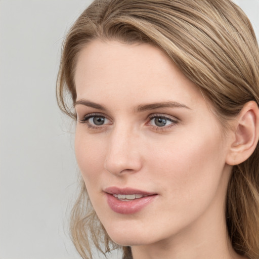 Joyful white young-adult female with long  brown hair and blue eyes