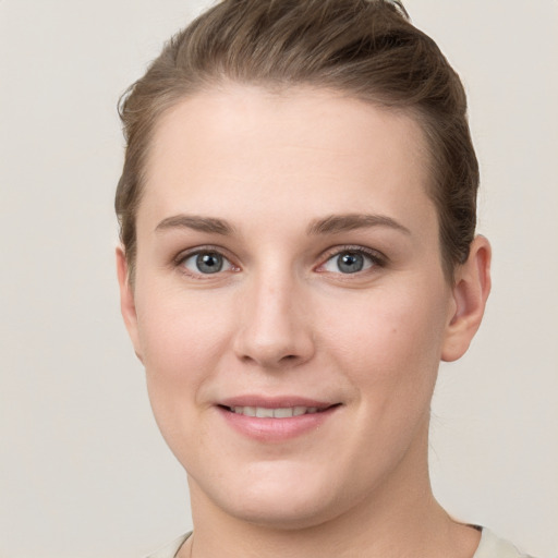 Joyful white young-adult female with short  brown hair and grey eyes