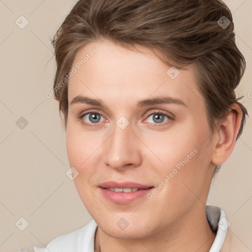 Joyful white young-adult female with short  brown hair and grey eyes