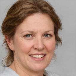 Joyful white adult female with medium  brown hair and blue eyes