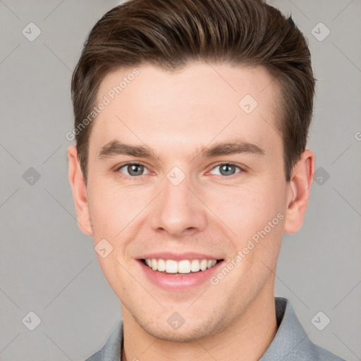 Joyful white young-adult male with short  brown hair and grey eyes