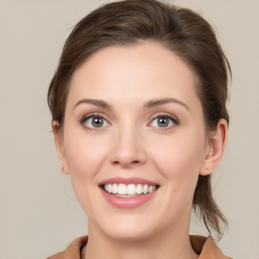 Joyful white young-adult female with medium  brown hair and grey eyes