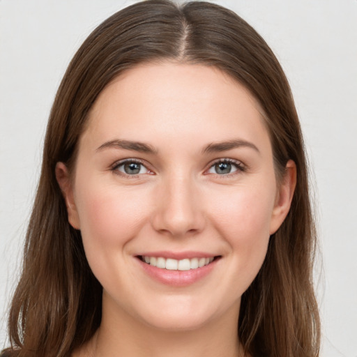 Joyful white young-adult female with long  brown hair and grey eyes