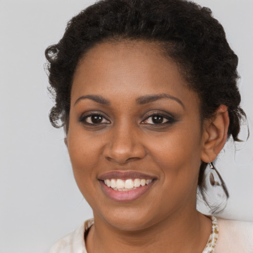 Joyful black young-adult female with short  brown hair and brown eyes