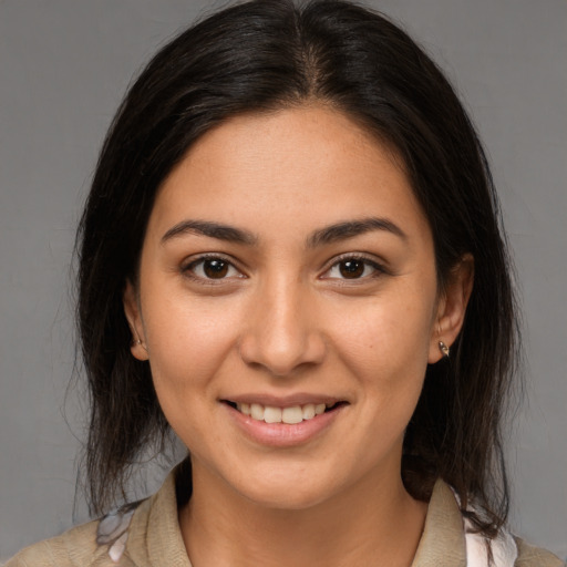 Joyful latino young-adult female with medium  brown hair and brown eyes