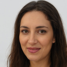 Joyful white adult female with long  brown hair and brown eyes