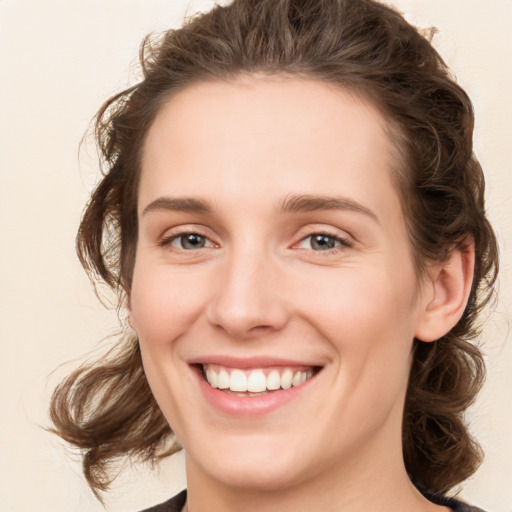 Joyful white young-adult female with medium  brown hair and green eyes