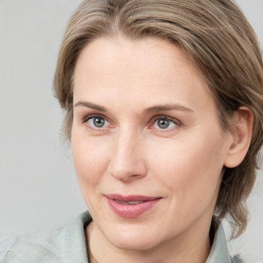 Joyful white adult female with medium  brown hair and blue eyes