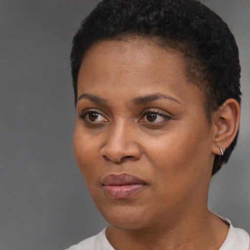 Joyful black young-adult female with short  black hair and brown eyes